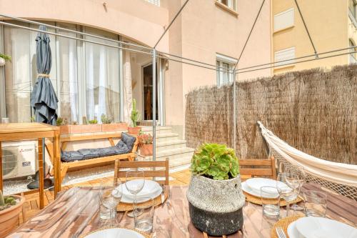 d'une terrasse avec une table, des chaises et un hamac. dans l'établissement L'Emeraude Varoise - Appt climatisé proche plage, à Six-Fours-les-Plages