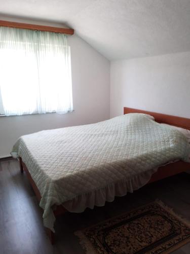 a bedroom with a large bed with a window at House Otes Ilidža in Sarajevo