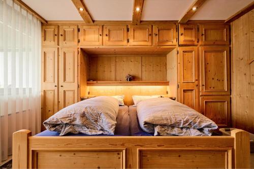 - 2 lits dans une chambre avec des armoires en bois dans l'établissement Fereinwohnung Flussrauschen, à Kirchberg in Tirol