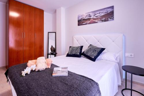 カラフェルにあるDivas houseのベッドルーム1室(白いシーツと木製キャビネット付)