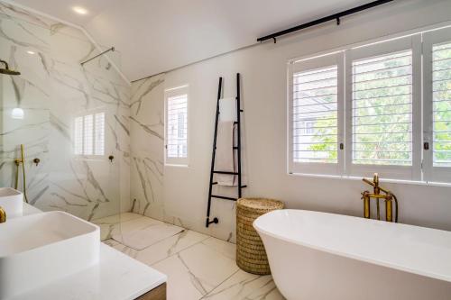 un bagno bianco con vasca e lavandino di Oranjezicht Heritage Home a Città del Capo