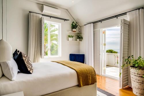 een slaapkamer met een groot bed en een raam bij Oranjezicht Heritage Home in Kaapstad