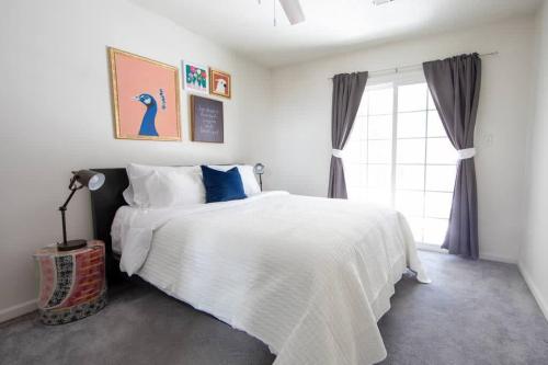 1 dormitorio con cama blanca y ventana en Cheerful 2 Bedroom Home near Virginia Wesleyan, en Virginia Beach