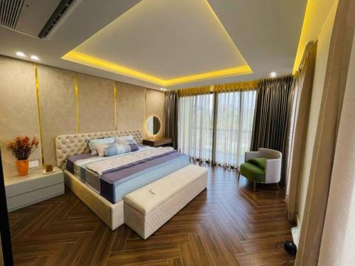 a bedroom with a king sized bed and a chair at Villa The Tropicana NVW Hồ Tràm in Ấp Thanh Bình