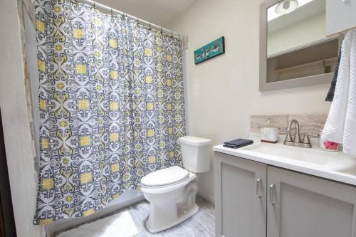 y baño con aseo y cortina de ducha. en Cheerful 2 Bedroom Home near Virginia Wesleyan, en Virginia Beach