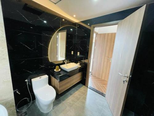 a bathroom with a toilet and a sink and a mirror at Villa The Tropicana NVW Hồ Tràm in Ấp Thanh Bình