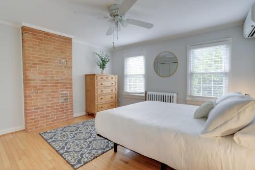 a bedroom with a white bed and a brick wall at Sojourn Historic Location 2 BR 2 BA in Washington