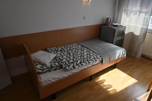 a small bed in a room with a wooden floor at SP ZOZ Sanatorium Uzdrowiskowe MSWiA w Kołobrzegu in Kołobrzeg