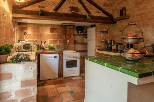 a kitchen with stone walls and a counter top at HOTEL et APPARTEMENTS DOMAINE DES CLOS - Teritoria in Beaucaire