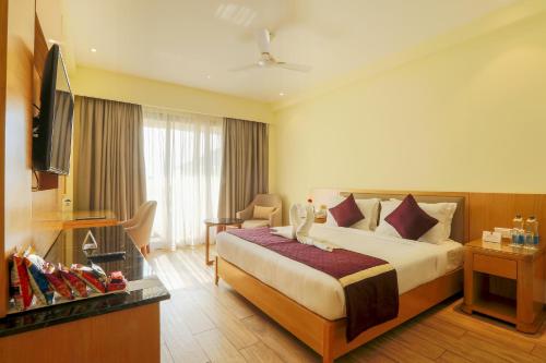 Habitación de hotel con cama y TV en Resort De Coracao - Calangute , Goa, en Calangute