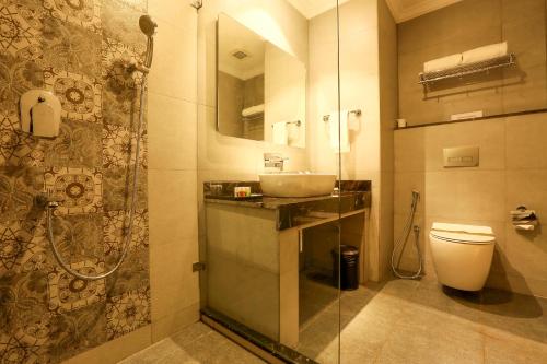 a bathroom with a sink and a toilet and a shower at Resort De Coracao - Calangute , Goa in Calangute