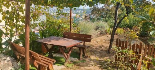 einen Holztisch und eine Bank in einem Garten in der Unterkunft Cozy Studio in Belgrad