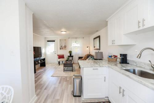 a kitchen with white cabinets and a living room at Sojourn Beachside Hideaway 2 BR in Norfolk