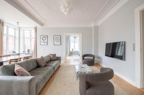 a living room with a couch and a tv at Perfect Holiday Homes Near Amager Beach in Copenhagen