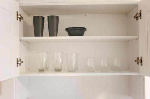a row of glasses sitting on a shelf at Sojourn Beachside Hideaway 2 BR in Norfolk