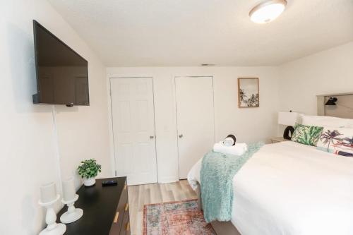 a bedroom with a large bed and a flat screen tv at Sojourn Beachside Hideaway 2 BR in Norfolk