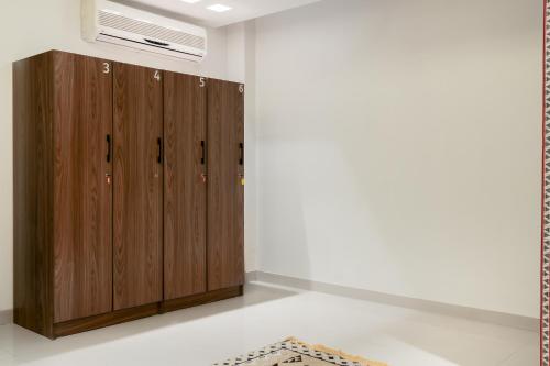 a room with wooden cabinets and a white wall at Sands Inn Hostel in Riyadh
