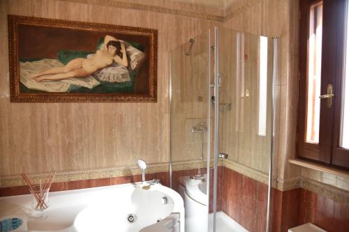 Masseria Fragnale في فاسانو: حمام به لوحة لامرأة على سرير