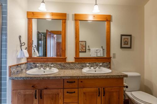 a bathroom with two sinks and a mirror at Cabins 24 in Mammoth Lakes