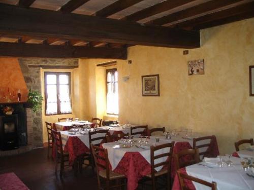 a dining room with tables and chairs with white table cloth at Agriturismo Le Scuderie in Carpineti