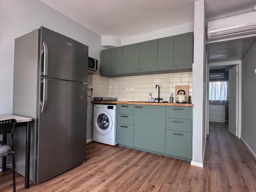 a kitchen with green cabinets and a refrigerator at Apartament - Lev Eilat 3 in Eilat