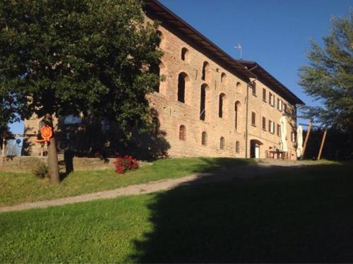 a large brick building with a tree in front of it at Agriturismo Le Scuderie in Carpineti