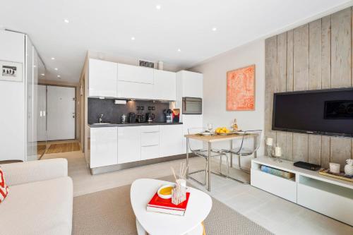 Il comprend un salon avec des placards blancs et une cuisine. dans l'établissement Downtown Cannes Modern 1-Br Apartment, à Cannes