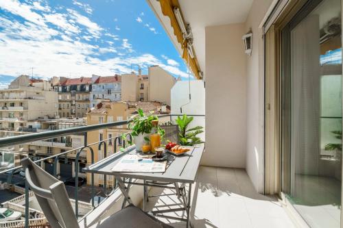 une table sur un balcon avec vue sur une ville dans l'établissement Downtown Cannes Modern 1-Br Apartment, à Cannes