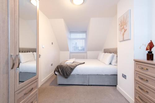 a small bedroom with a bed and a mirror at Beautiful Cottage in Durham with Pool Table in Durham