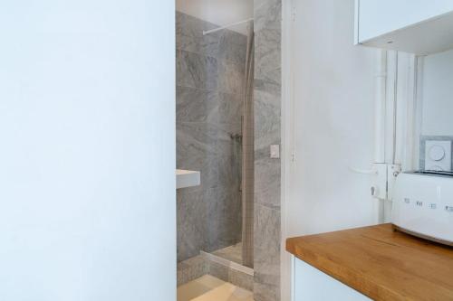 une salle de bain avec une douche avec une porte vitrée dans l'établissement Le Plaisir du Pantheon, à Paris