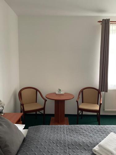 a room with a table and two chairs and a table at Hotel Karolina in Karlovy Vary