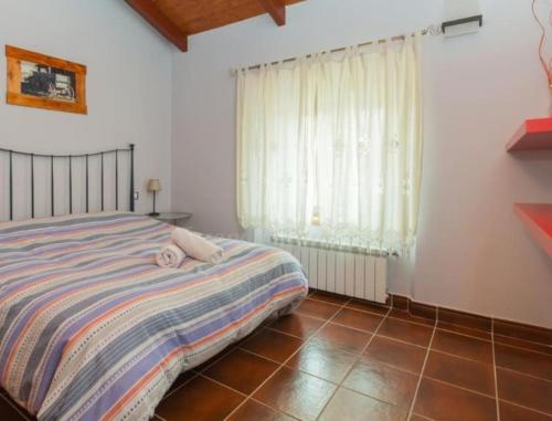 a bedroom with a bed and a window at blasón conde de castro in Santo Tomé de Zabarcos