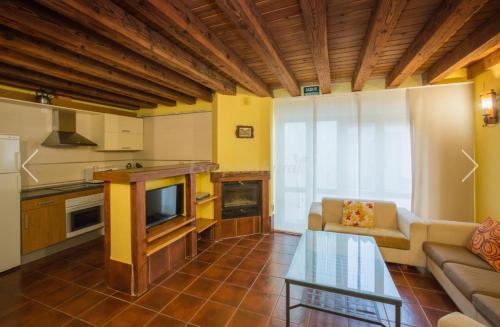a kitchen and living room with a couch and a table at blasón conde de castro in Santo Tomé de Zabarcos