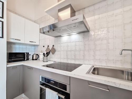a white kitchen with a sink and a microwave at Il Passatore in Forlì