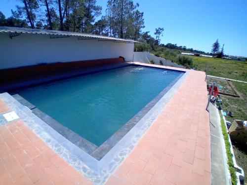 a large swimming pool in a yard with a house at UFitness Hotel in Vila Real de Santo António