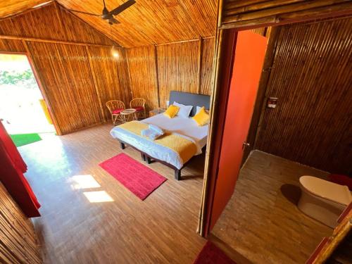um quarto com uma cama e um sofá num quarto em Romanchgiri Adventure Resort em Kāndi