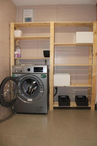 Eine Waschmaschine befindet sich neben einem Regal in der Unterkunft mezzanino Ribeira Brava in Vila da Ribeira Brava