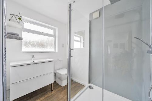 uma casa de banho branca com um lavatório e um chuveiro em Waters Edge Holiday Home in Hayle, West Cornwall em Hayle