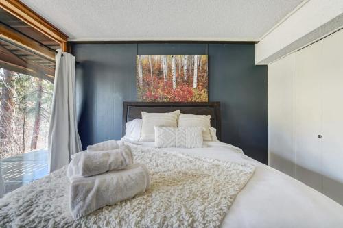 a bedroom with a white bed with a window at 4BR Cabin Mountain Views with Fireplace in Cascade-Chipita Park