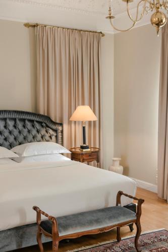 a bedroom with a bed and a chair and a lamp at Noble Suites in Athens