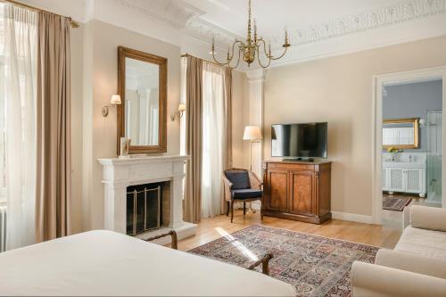 a living room with a fireplace and a television at Noble Suites in Athens