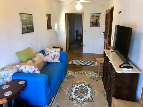 a living room with a blue couch and a flat screen tv at Casa David in Castelo de Vide