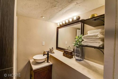 ein Bad mit einem Waschbecken und einem Spiegel in der Unterkunft Manitou Springs Downtown Escape in Manitou Springs