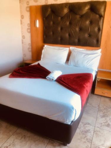 1 dormitorio con 1 cama grande y cabecero grande en Andrienne Lodge Cape Town, en Ciudad del Cabo