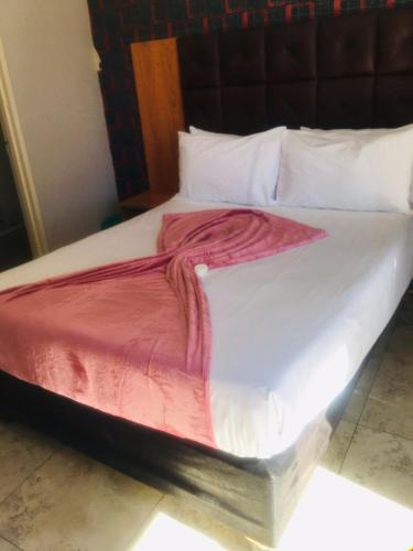 a white bed with a red blanket on it at Andrienne Lodge Cape Town in Cape Town