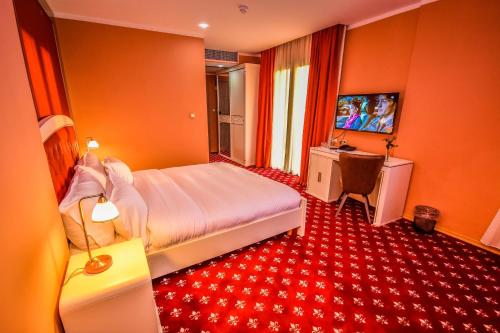 a bedroom with a bed and a desk and a television at HOTEL PLAZA ORAN in Oran