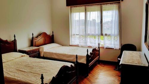 a bedroom with two beds and a window at Casa Vacacional las Tercias in Niembro