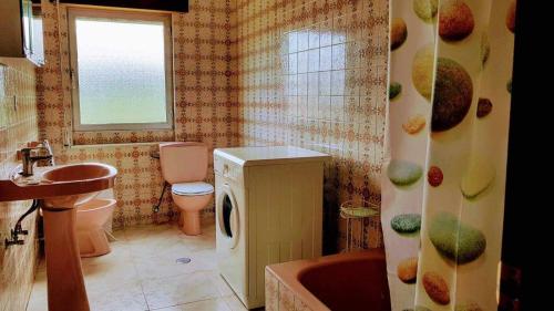 a bathroom with a sink and a washing machine at Casa Vacacional las Tercias in Niembro