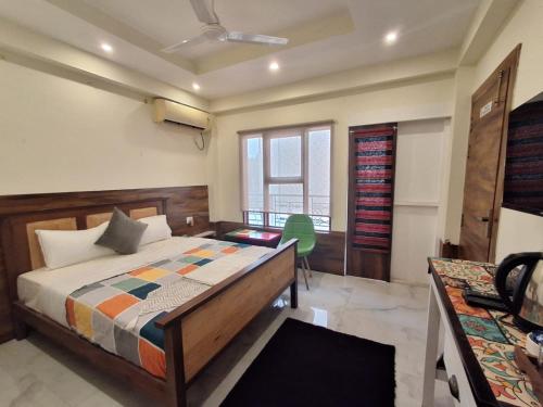 a bedroom with a bed and a green chair in it at Date Palm Home Stay in Tezpur