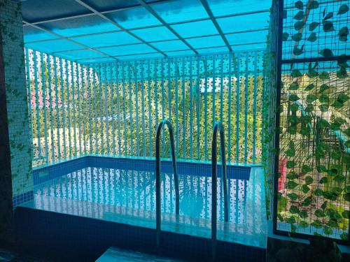 una piscina con una valla de cristal alrededor en Mary Land Homestay en Thiruvananthapuram